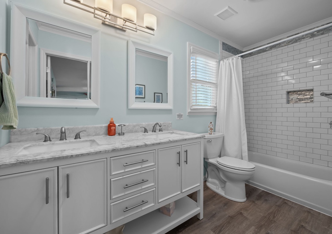 Refresh in your elegant bathroom featuring marble countertops, dual vanities, and a subway-tiled tub for relaxing soaks.