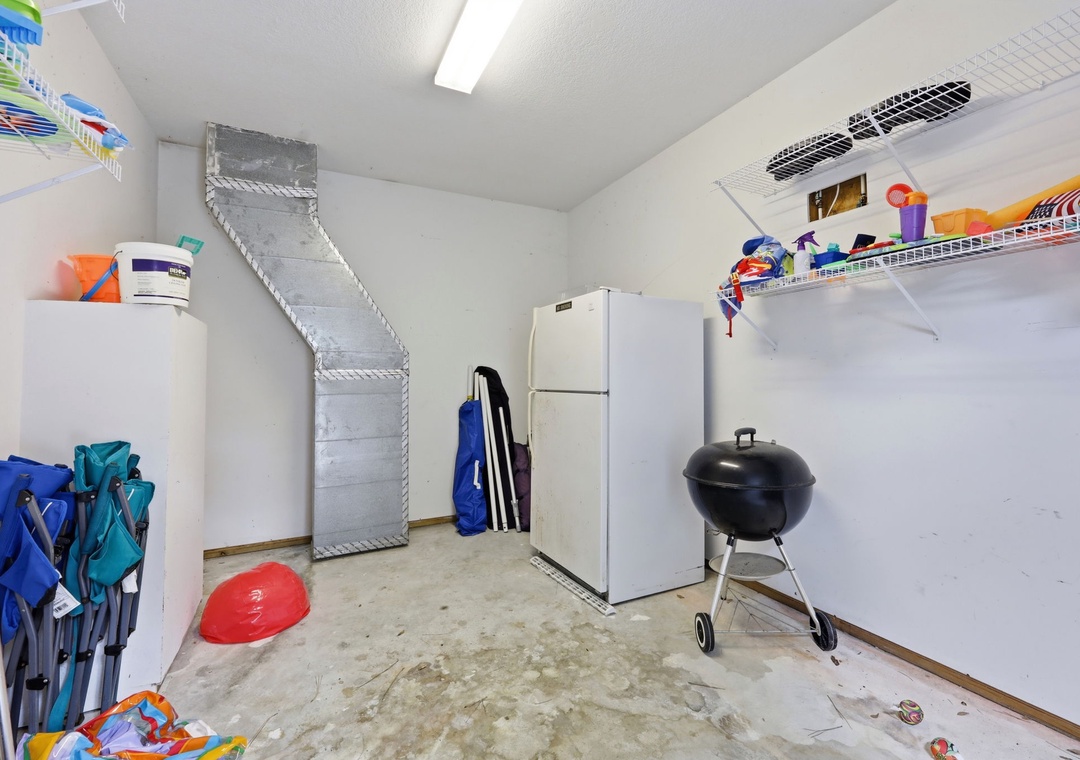 This utility space includes storage, a refrigerator, and BBQ grill—practical amenities to enhance your stay with convenience and outdoor cooking options.