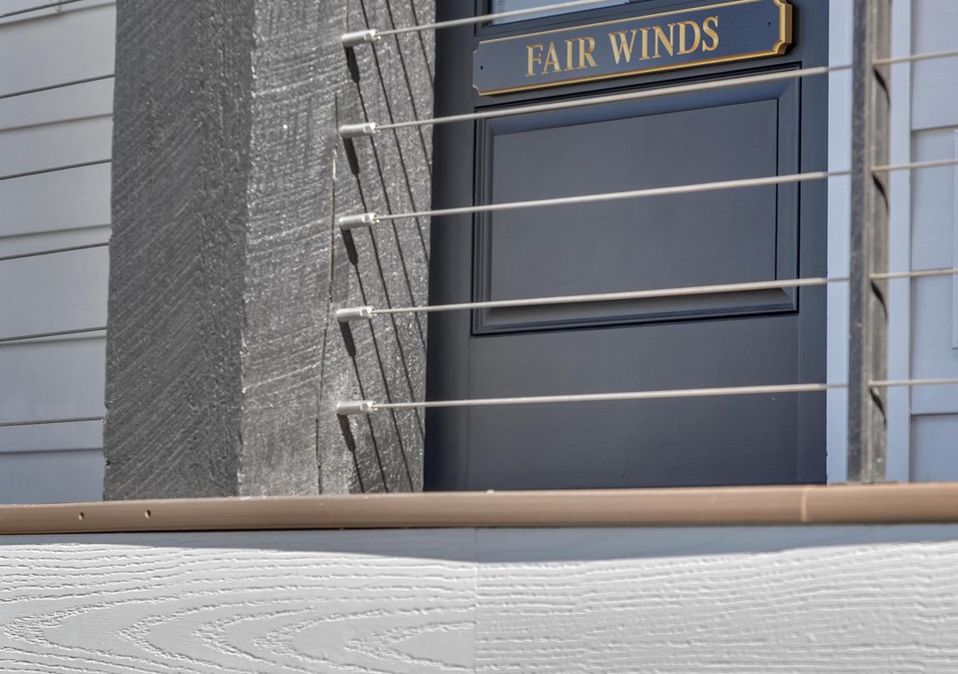Welcome to Fair Winds. This charming property features a modern façade with clean lines and coastal character, marking your arrival at a relaxing coastal retreat.