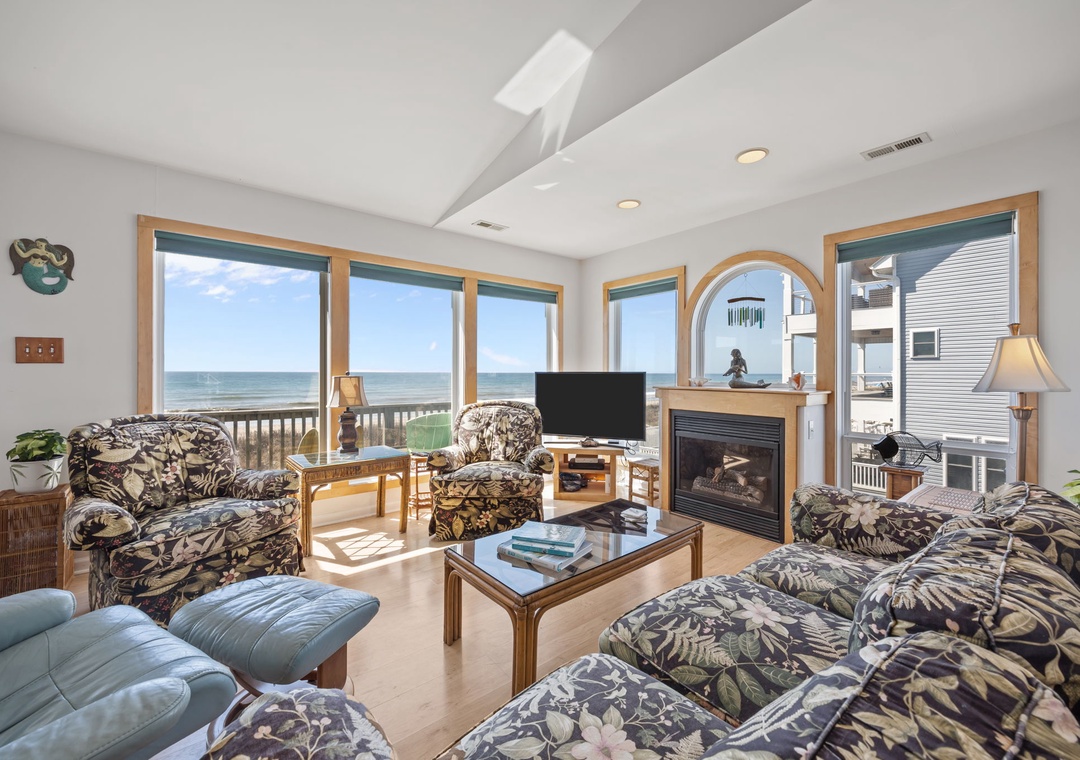 Relax in your oceanfront living room where panoramic sea views stretch endlessly beyond floor-to-ceiling windows, creating the perfect coastal retreat.