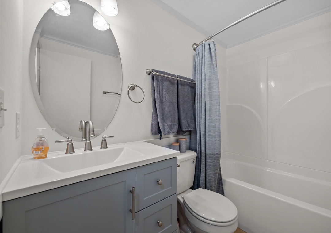 Your pristine bathroom features a sleek tub-shower combo, elegant vanity, and fresh towels—perfect for unwinding after your adventures.