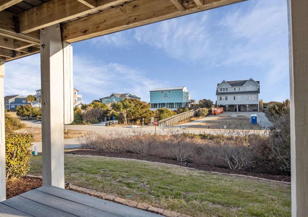 A covered outdoor area provides views of the residential neighborhood and nearby coastal community.