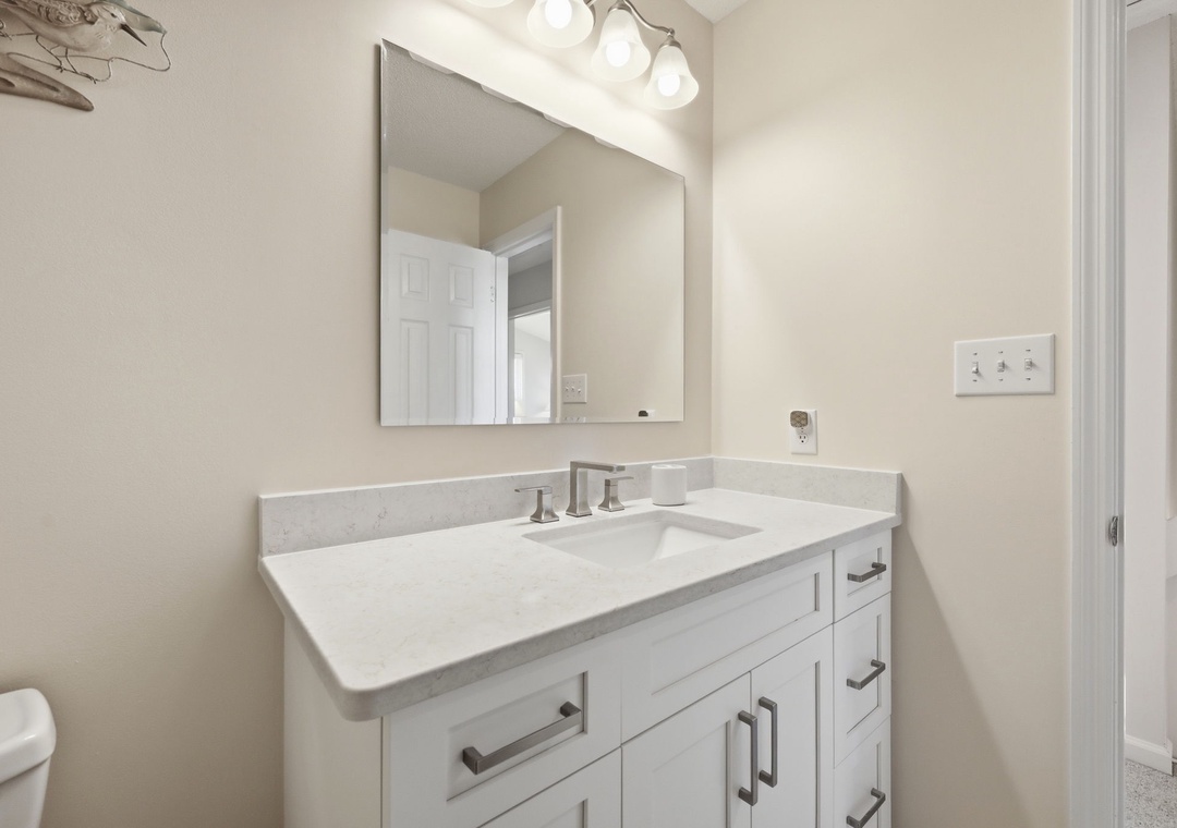 Freshen up at this clean, well-lit vanity with marble countertops and sleek modern fixtures—your perfect spot to start and end your day in comfort.