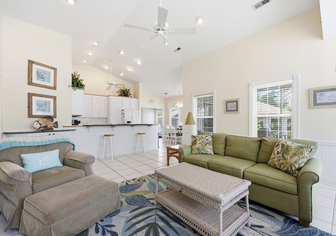 Relax in your open-concept living area with vaulted ceilings, cozy seating, and a fully equipped kitchen. Natural light fills the space, creating a breezy, coastal atmosphere for your stay.