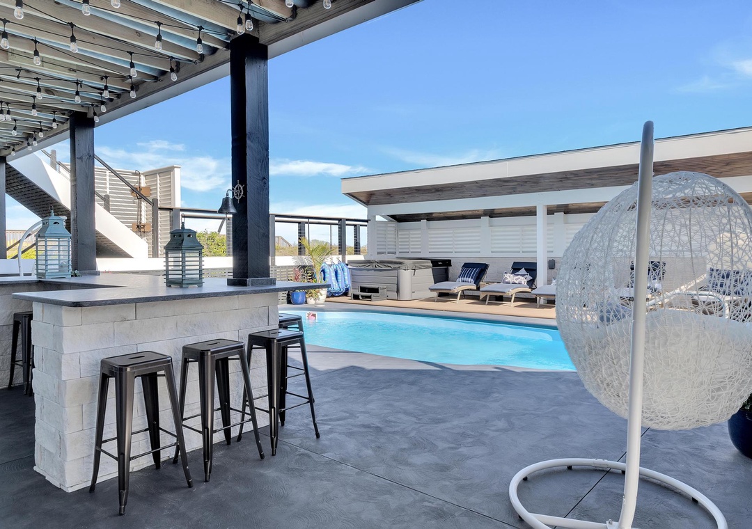 Sip morning coffee at the bar or lounge in the hanging chair overlooking your private pool—a perfect blend of relaxation and modern style under sunny skies.