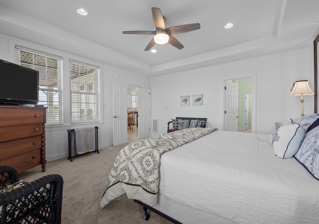 Drift off in your elegant bedroom with crisp linens, ceiling fan comfort, and TV entertainment for the perfect night's rest.