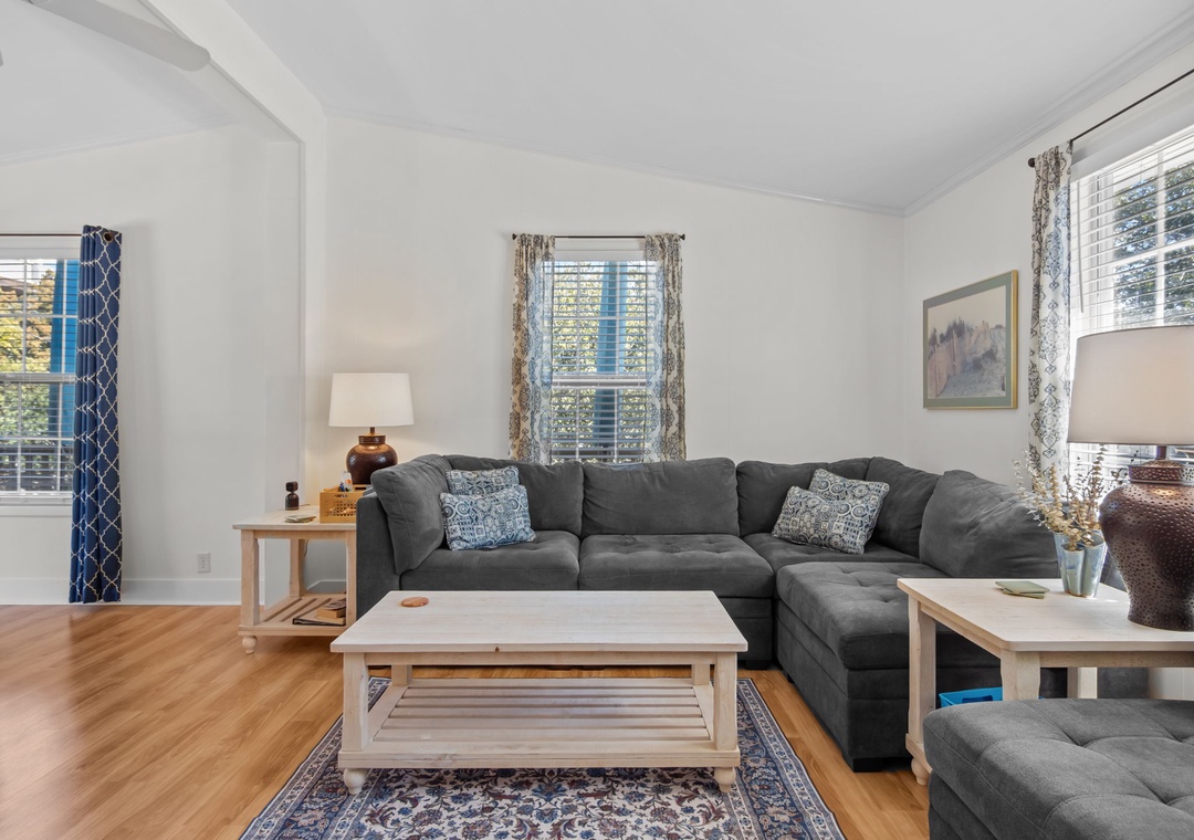 Sink into this plush sectional where natural light streams through patterned curtains, creating your perfect retreat for relaxing after exploring.
