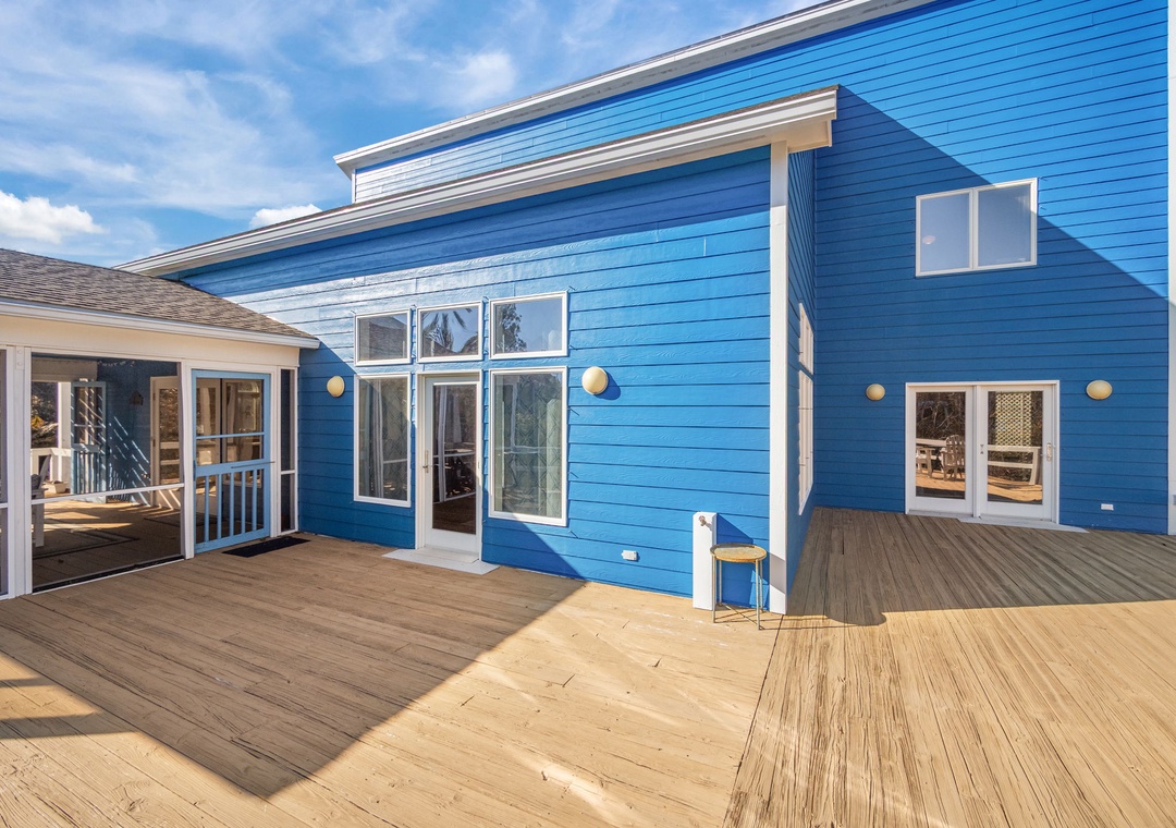 Modern blue beach house with expansive deck offering oceanfront charm and sunny outdoor living spaces.