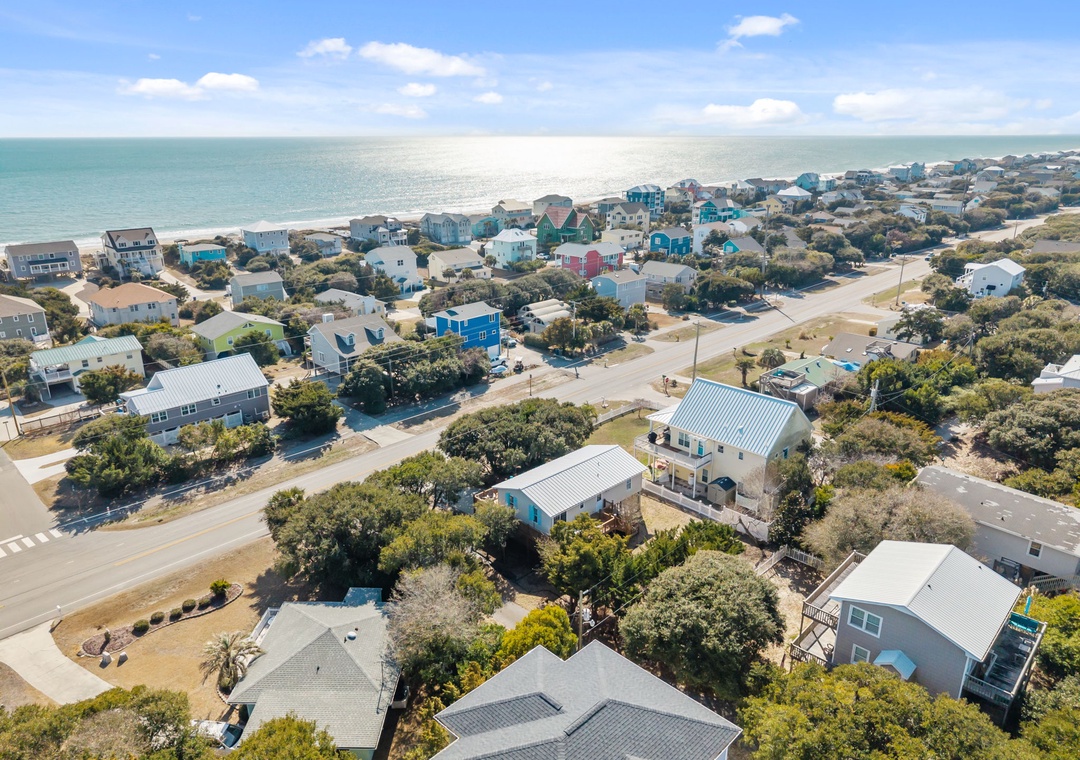 Charming coastal community with colorful beach houses nestled among mature trees, just steps from pristine shores.