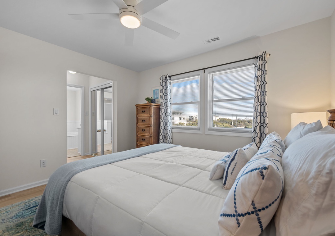 Drift off to sleep in your serene bedroom, where soft linens and a gentle ceiling fan create the perfect sanctuary for restful nights.