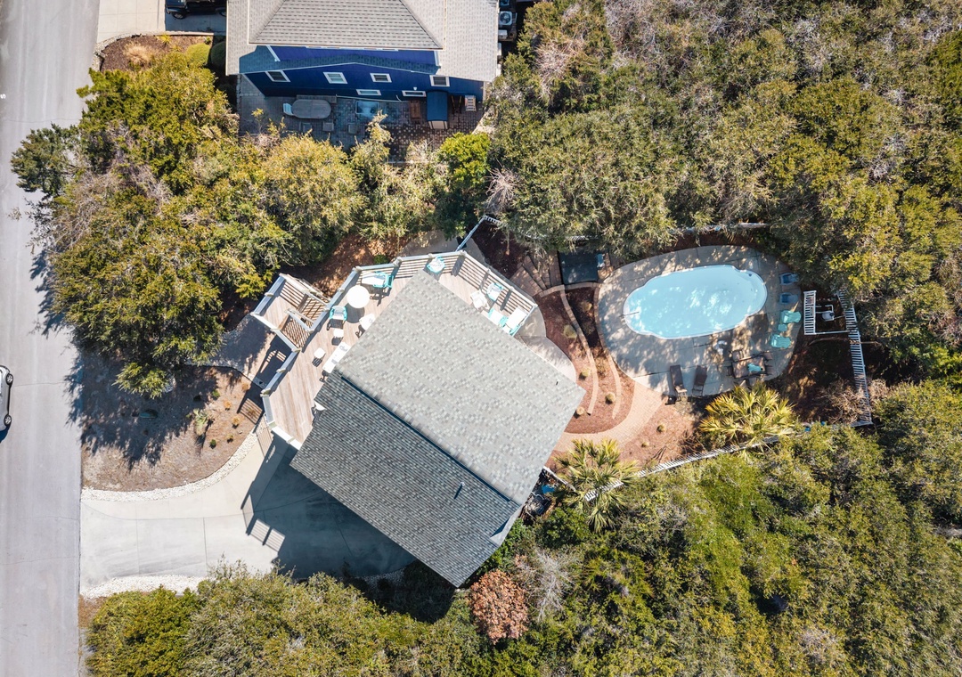 Aerial view showcases the property nestled among mature trees with a private swimming pool and spacious outdoor areas for relaxation.