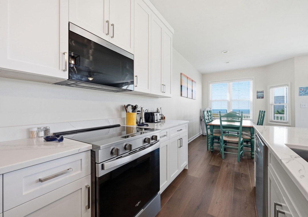 The fully equipped kitchen and dining area feature modern appliances, bright coastal light, and stunning water views—making every meal a memorable experience.