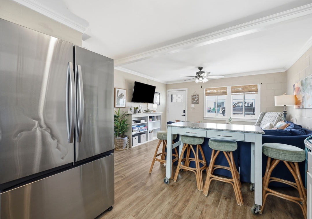 Gather around this inviting kitchen island with comfy seating while you prepare meals with modern stainless-steel appliances. Natural light fills your space, creating a warm atmosphere for cooking and connecting.