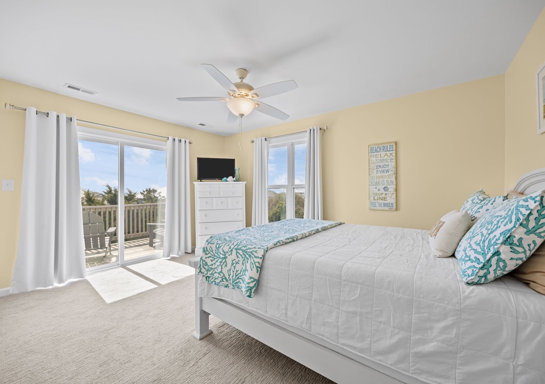 Wake up to ocean breezes in your coastal bedroom, where coral-patterned linens and balcony access create your perfect beach retreat.