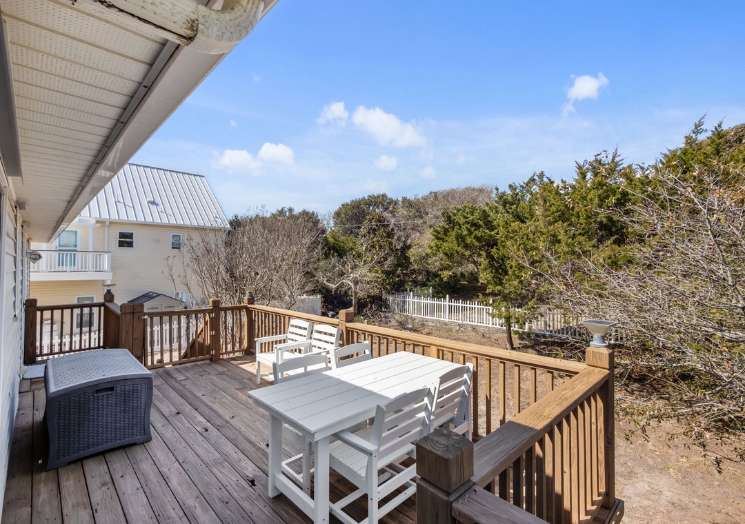 Step onto your private deck and savor peaceful moments at the outdoor dining table, surrounded by coastal charm and blue skies.