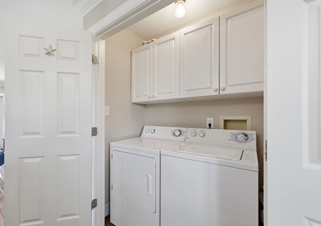 Your vacation laundry is effortlessly handled in this bright, dedicated space with a full-sized washer and dryer, plus plenty of overhead storage to keep everything tidy.