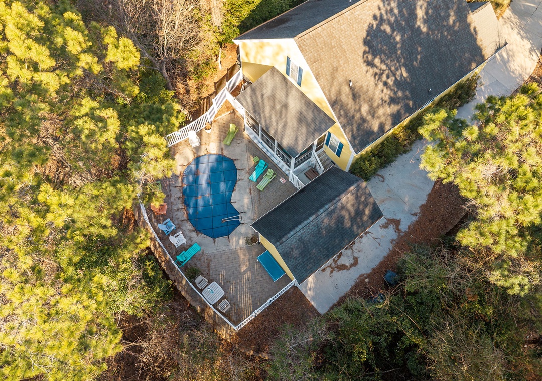 Aerial view of vacation rental nestled among lush trees with private pool and outdoor deck areas.