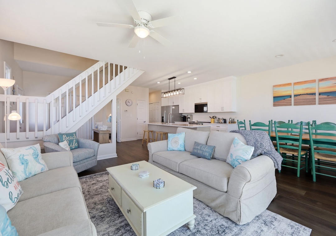 Sink into plush sofas in this bright, airy living space where coastal charm meets comfort. The open layout flows seamlessly into your fully-equipped kitchen and dining area, perfect for togetherness.