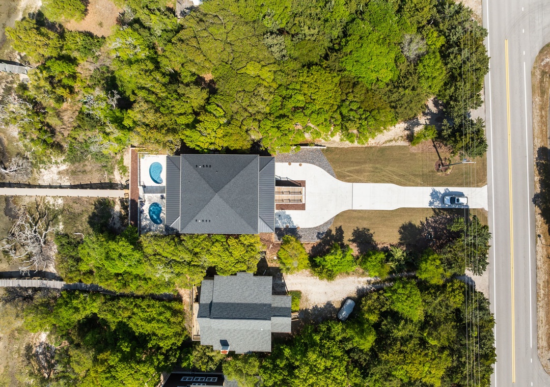 Aerial view of the vacation rental property surrounded by lush greenery, featuring a swimming pool and spacious outdoor areas.