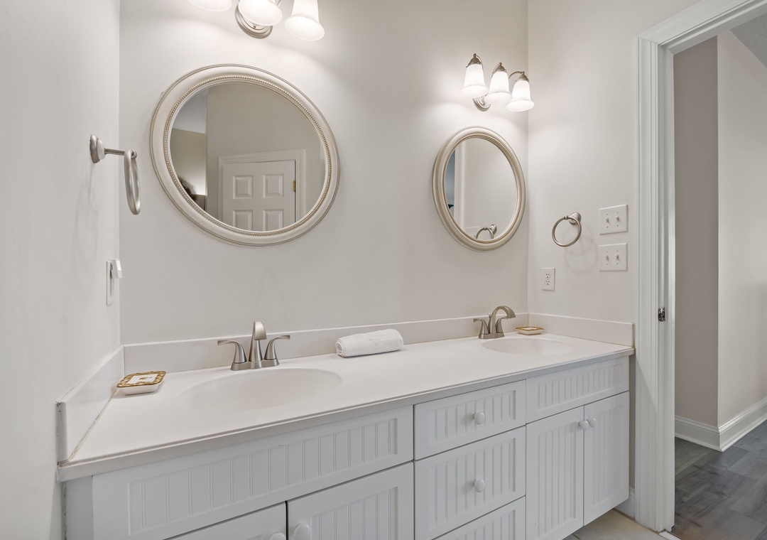 Refresh in your elegant dual-vanity bathroom with gleaming mirrors and crisp white cabinetry—perfect for sharing your morning routine.