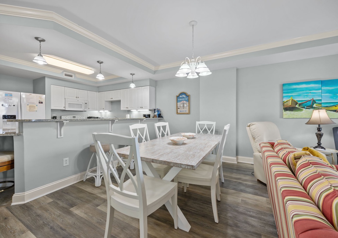 Your open-plan kitchen and dining area features crisp white cabinetry, granite counters, and a welcoming table perfect for shared meals.