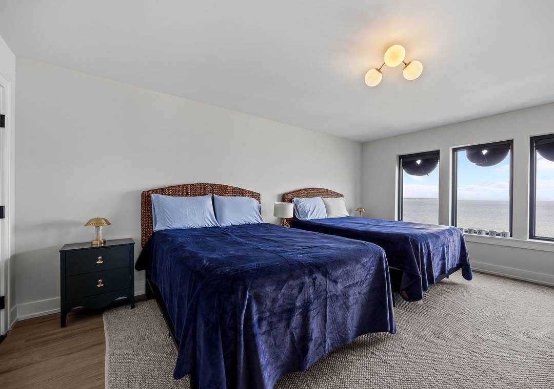 Wake up to stunning ocean views from your comfortable twin beds with coastal-inspired wicker headboards and plush navy bedding.
