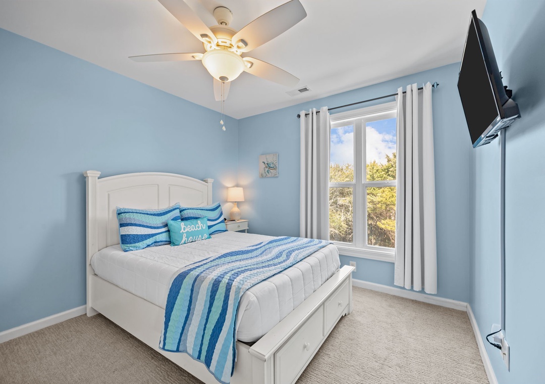 Drift off in this serene coastal bedroom with tranquil blue tones, comfortable bedding, and natural light streaming through your window.