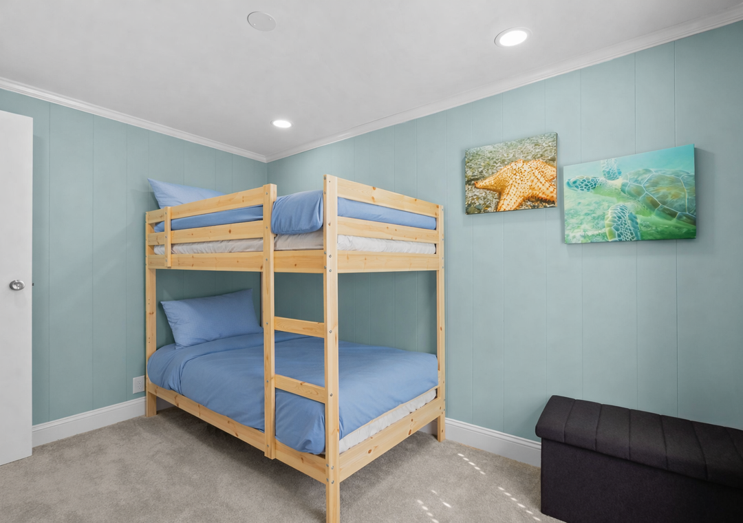 Your kids will love this cheerful bunk bed room with ocean-themed artwork and soft blue linens for cozy nights.