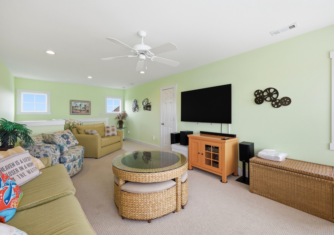 Your bright, cheerful living room invites you to unwind with comfortable seating, tropical touches, and entertainment ready for movie nights or game days after beach adventures.