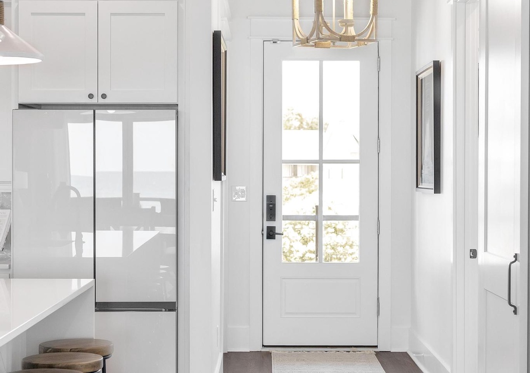 Step into a bright, modern kitchen with farmhouse charm, where crisp white cabinetry, warm wood beams, and gleaming appliances await your culinary adventures.