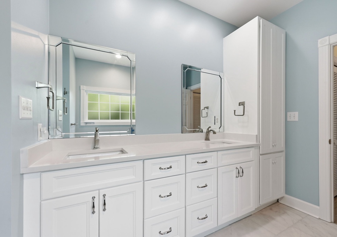 Pamper yourself in this spa-like bathroom with dual vanities, sleek white cabinetry, and abundant storage—your personal oasis awaits.