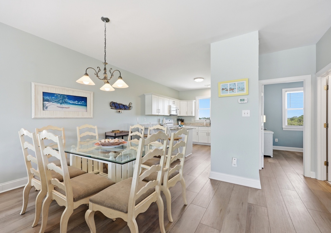 Gather around this inviting dining table for meals with loved ones. The bright open kitchen and coastal decor create a relaxed, beach-inspired atmosphere you'll love coming home to.