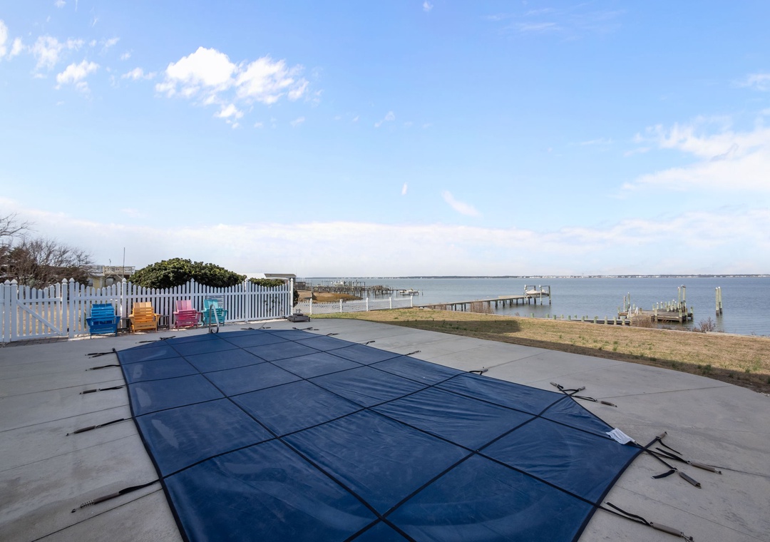 Waterfront property with covered pool overlooking peaceful bay waters and private docks for scenic coastal relaxation.