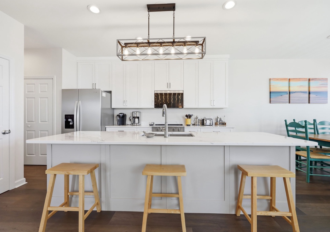 You'll love preparing meals in this bright, open kitchen with its generous island, modern appliances, and soothing coastal touches throughout.