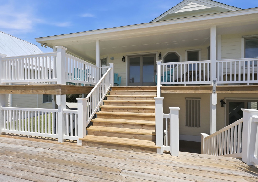 A spacious multi-level deck with covered porch overlooking the coastal area, offering outdoor living and scenic surroundings for the property.