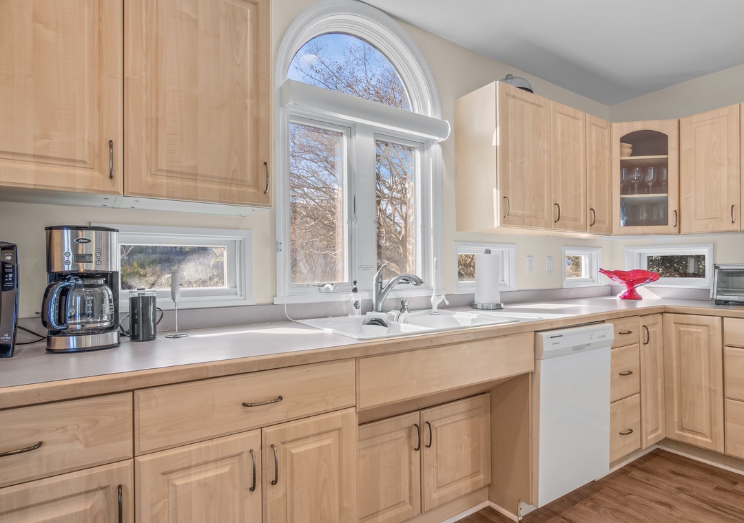 Cook your favorite meals in this fully equipped kitchen with natural maple cabinetry, modern appliances, and beautiful arched windows.