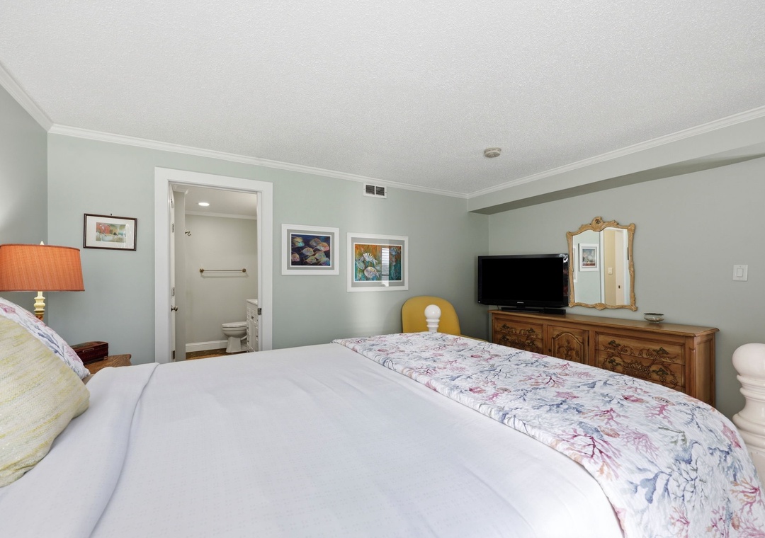 Unwind in your calming bedroom, where soft sage walls and crisp white linens create a peaceful retreat after a day of exploring. An en-suite bathroom adds convenience to your stay.