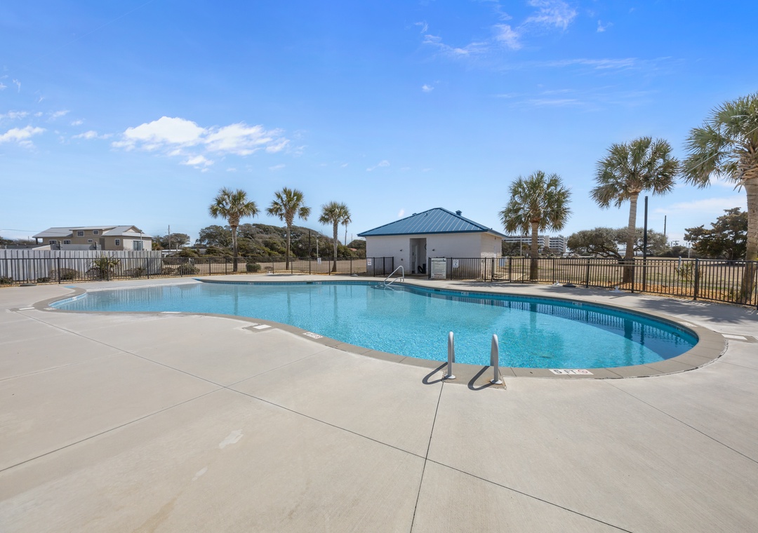 Crystal-clear community pool surrounded by palm trees under Florida's endless blue sky.