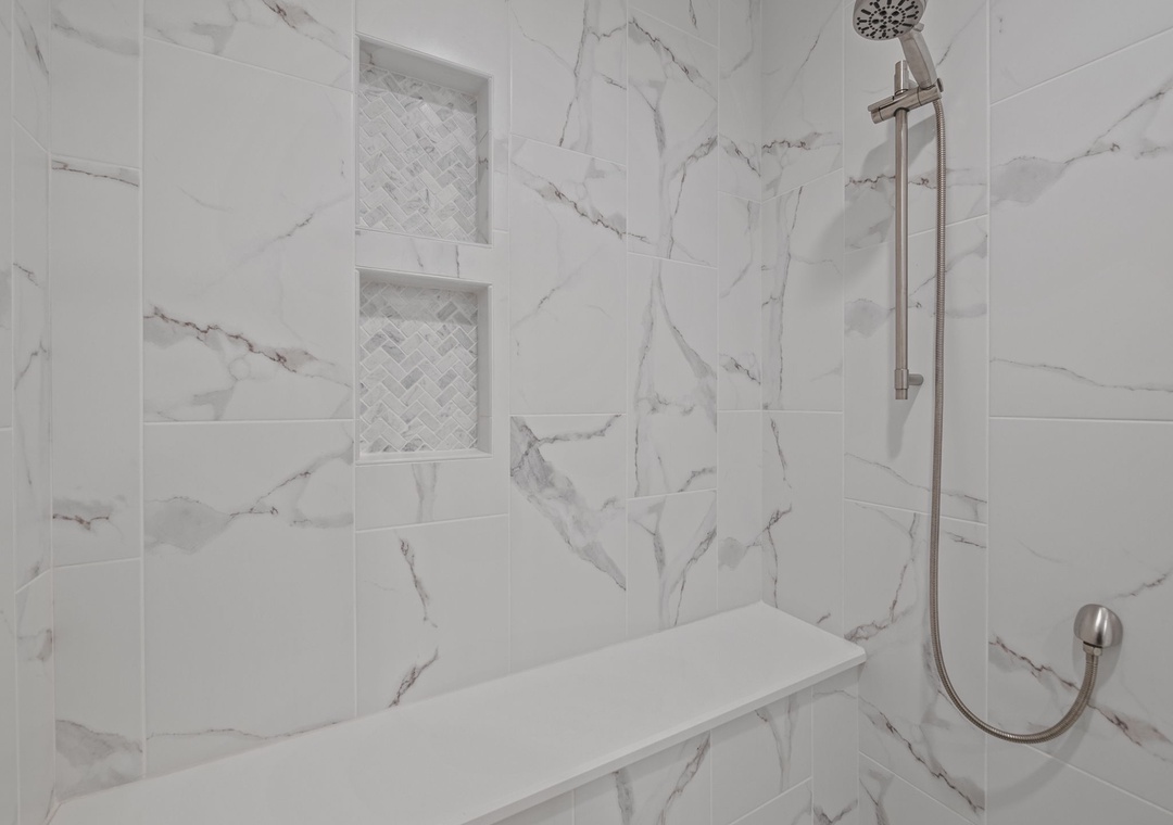 Step into your luxurious marble shower sanctuary, where elegant built-in niches hold your essentials and the rainfall head promises rejuvenating moments.