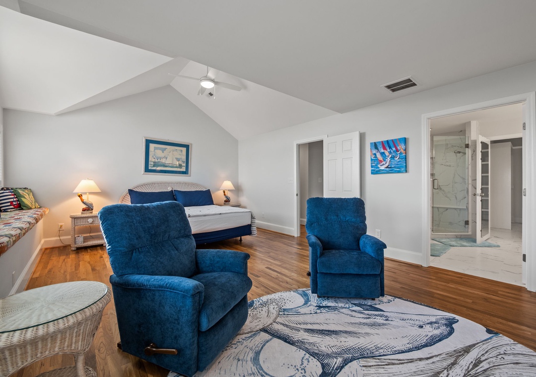 Your spacious bedroom suite features two cozy blue recliners where you can unwind, beautiful hardwood floors, and an elegant ensuite bathroom.