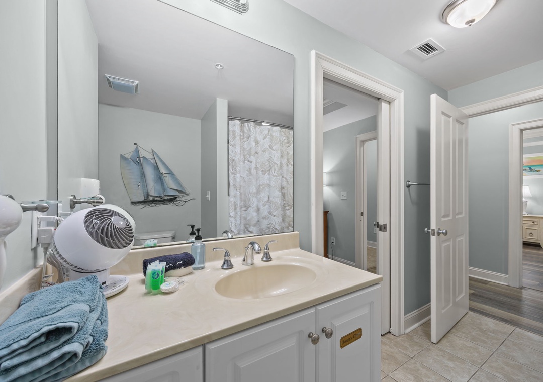 Refresh in this elegant bathroom with modern amenities and coastal touches, featuring a spacious vanity and convenient hair dryer for your comfort.