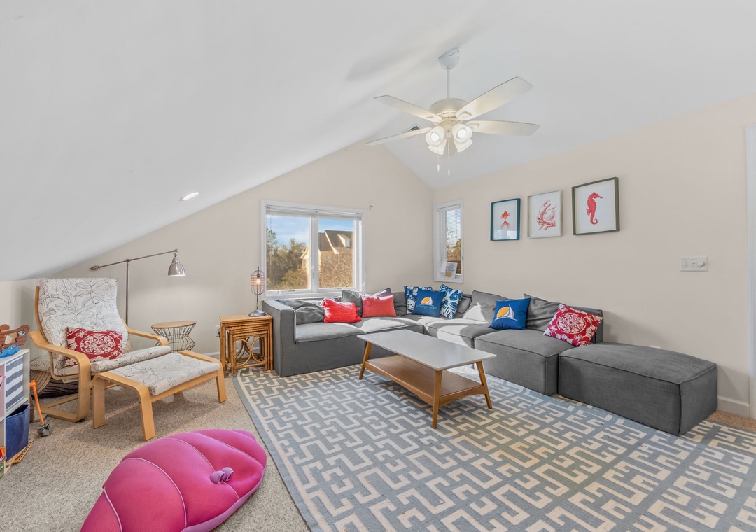 Relax in your spacious loft living room with vaulted ceilings, comfy sectional seating, and cheerful coastal touches.