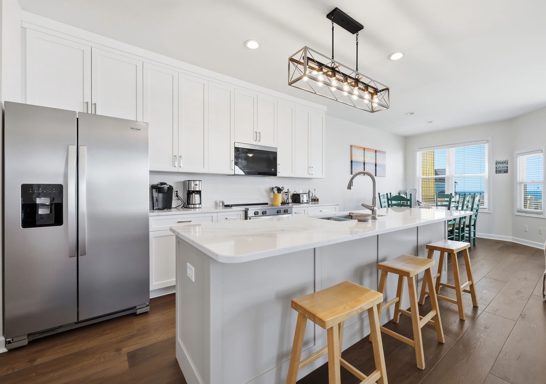 Picture yourself cooking in this modern kitchen with sleek appliances, spacious countertops, and an inviting island for morning coffee. Ocean views await just beyond the dining area.