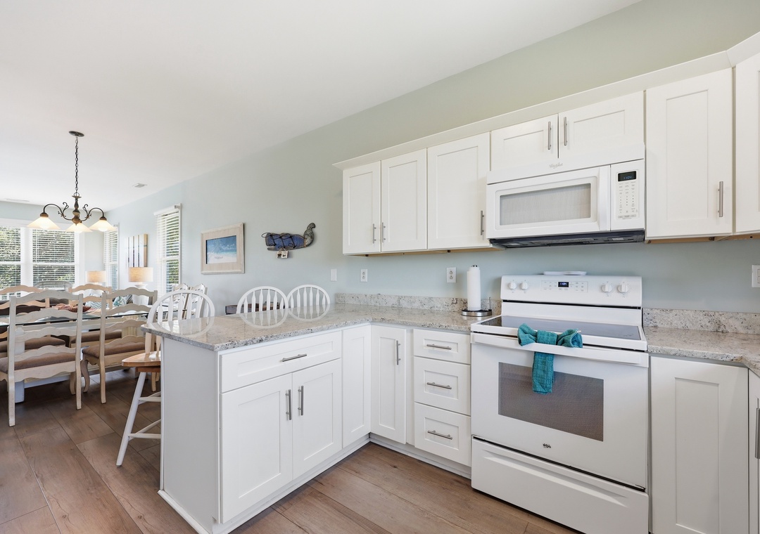 Step into your bright, open-concept kitchen with white cabinetry, granite countertops, and all the appliances you need to whip up your favorite meals. The adjoining dining space makes gathering with loved ones effortless and inviting.