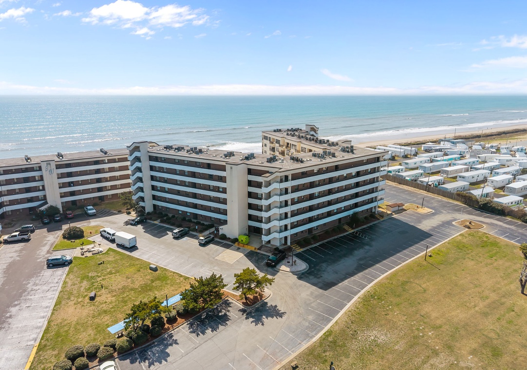 Beachfront property situated steps from the ocean with convenient parking and surrounded by coastal community. Multi-story building with direct beach access and sea views.