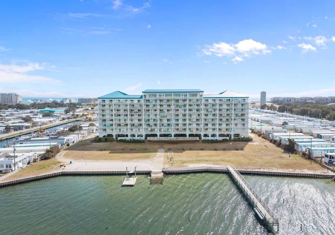 Waterfront resort complex featuring multiple buildings with distinctive turquoise roofing, positioned along a protected marina with private docks and boat access.