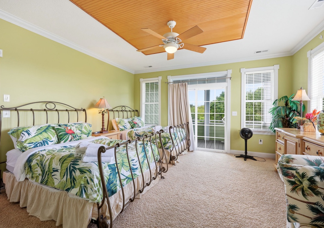 Wake up in your tropical-themed bedroom with botanical bedding and warm wood ceiling. French doors lead to your private patio, blending indoor comfort with outdoor charm.