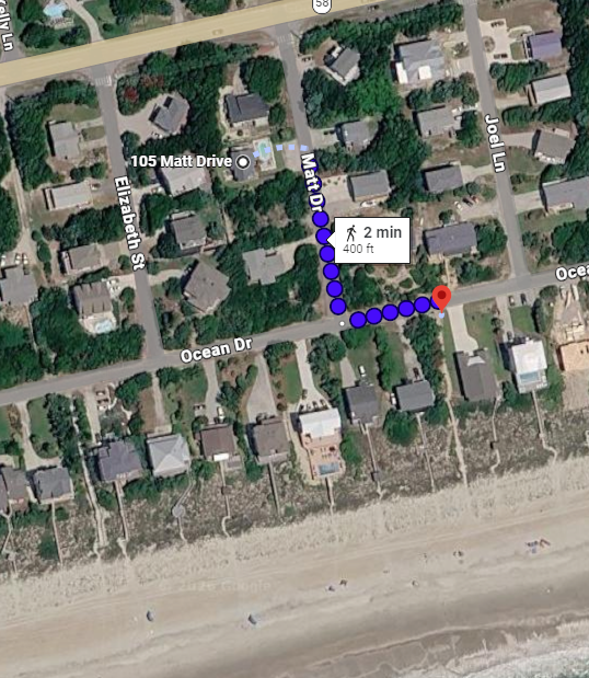 Aerial view of beachfront neighborhood with residential homes near sandy shoreline and ocean access.