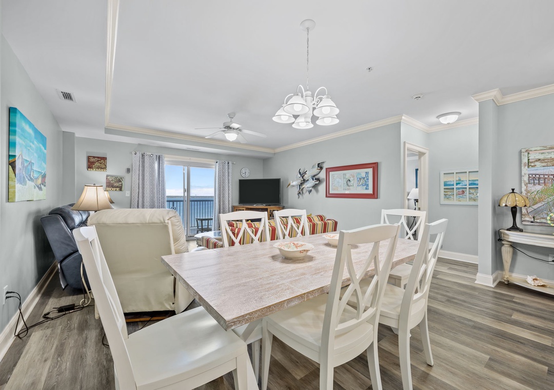 Step into your bright, coastal-themed living space where ocean views frame memorable meals around the elegant dining table.