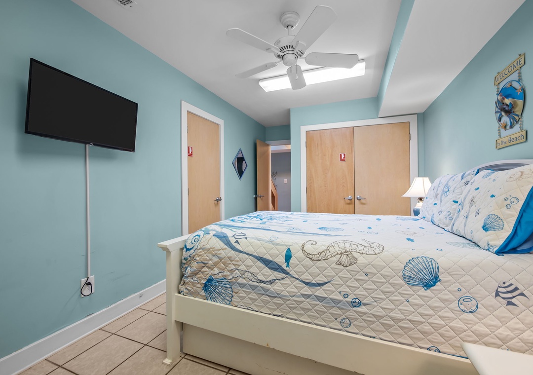 Your coastal-themed bedroom offers serene ocean vibes with sea-blue walls, charming shell bedding, and gentle ceiling fan breezes for ultimate relaxation.